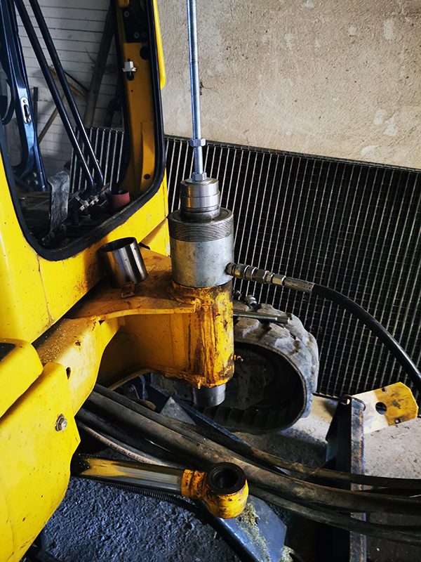 Hydraulisches Einpressen einer neuen Buchse in die Schwenkgelenkaufnahme eines Komatsu PC20R