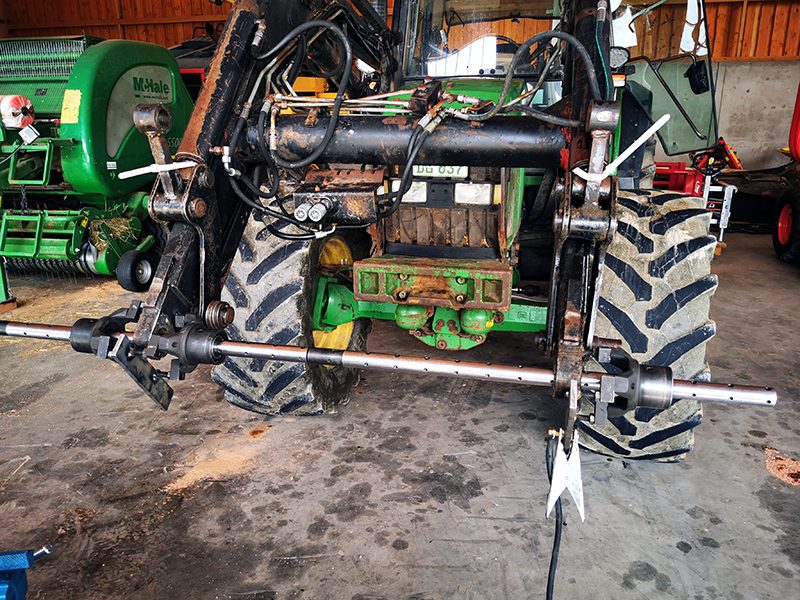 Frontlader eines John Deere Traktors mit aufgespannter Bohrstange, bereit zum mobilen Ausspindeln