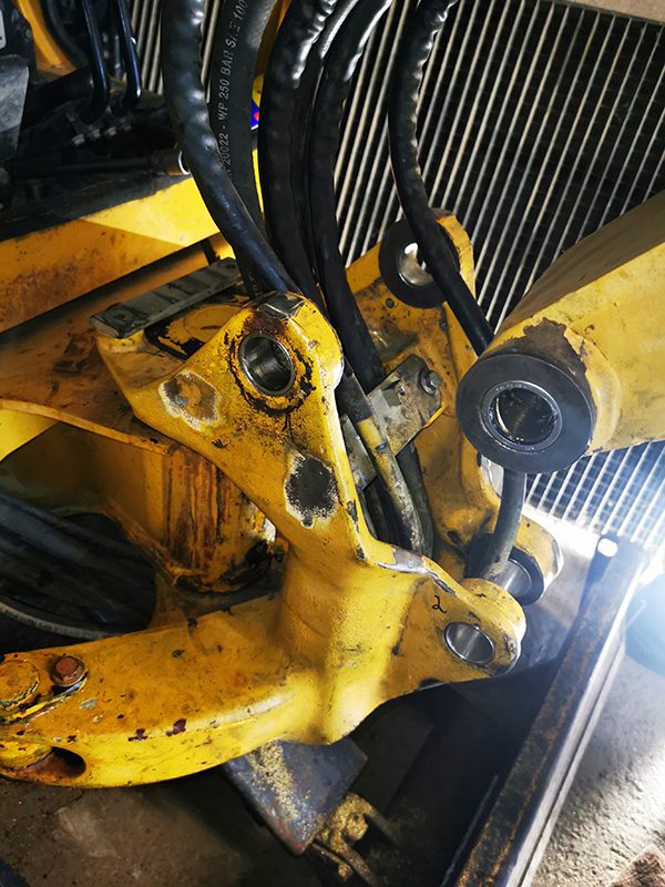 Montage des Hauptarms am Schwenkgelenk eines Komatsu PC20R mit neuen Buchsen