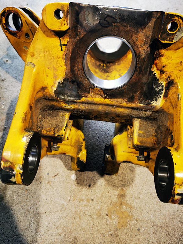 Eingepresste neue Buchsen im Schwenkgelenk eines Komatsu PC20R nach dem Ausspindeln