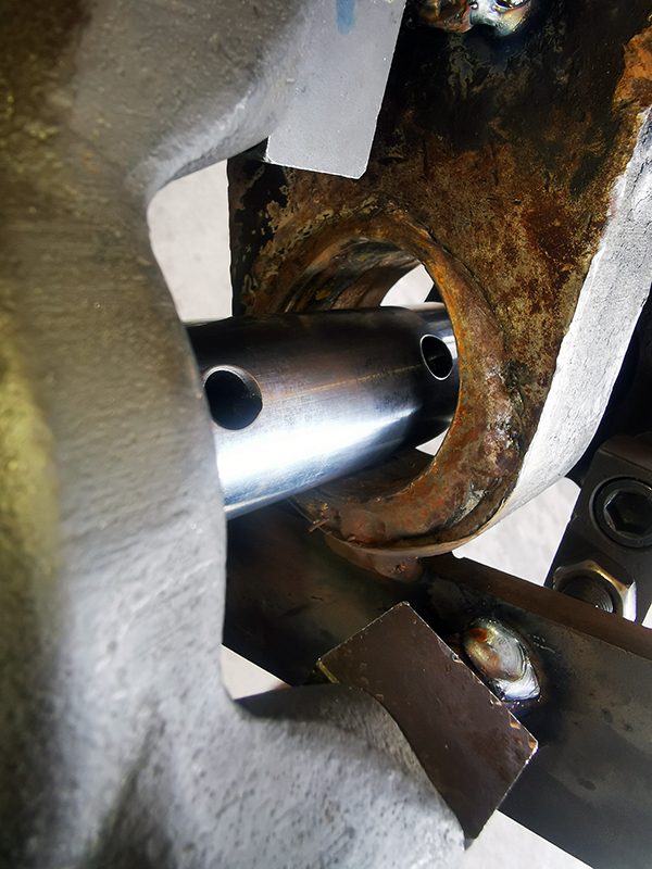 Nahaufnahme eines ausgeschlagenen Bolzensitzes an einem John Deere Frontlader vor der Bearbeitung